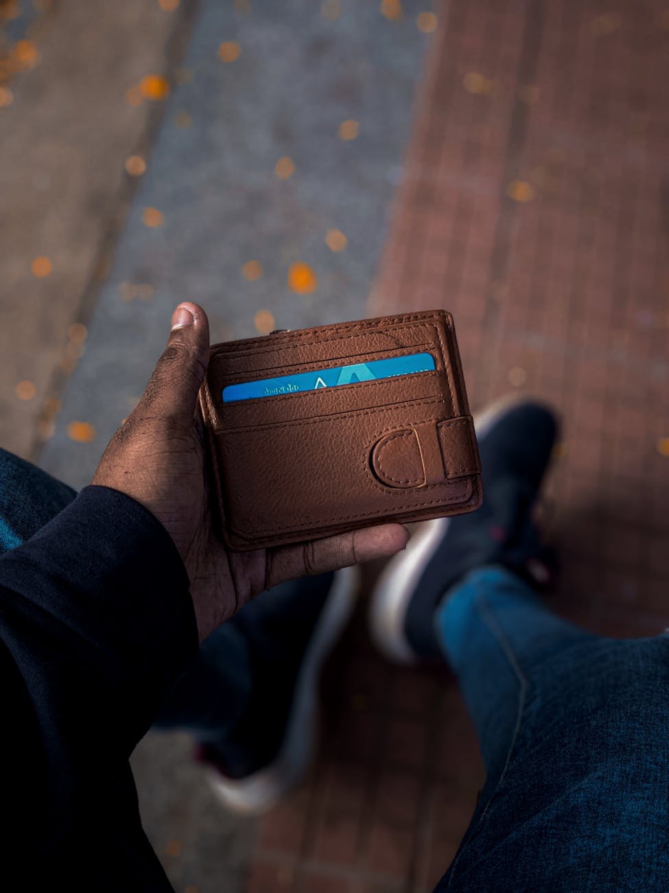 man holding brown leather wallet