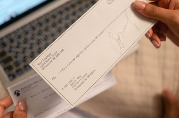 a person s hand holding a cheque